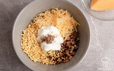 В подходящую емкость поместите охлажденные шампиньоны, тертый на мелкой терке желток, сыр. Добавьте майонез, посолите и поперчите на свой вкус, перемешайте.