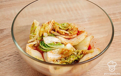 Залейте в миску с ингредиентами остывшую воду. Поставьте миску в холодильник, чтобы капуста мариновалась там двое суток. Достаньте блюдо из холодильника, слейте рассол и хорошо перемешайте. Готово!