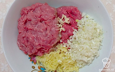 Очищенный лук нарежьте мелкими кубиками, чеснок пропустите через пресс, картофель натрите на мелкой терке. В глубокую миску выложите свино-говяжий фарш, добавьте подготовленные овощи, соль и молотый перец. Тщательно перемешайте все ингредиенты. Чтобы масса стала однородной, отбейте ее в течение нескольких минут об поверхность стола.