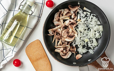 Подготовьте начинку. Разогрейте растительное масло на сковороде. Выложите в горячее масло лук и 1-2 минуты обжарьте, затем добавьте грибы и пожарьте все вместе примерно 4-5 минут, помешивая для равномерной обжарки.