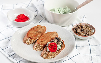 Соберите бутерброды. В миске вилкой разомните творожный сыр и авокадо или измельчите их погружным блендером, оставив небольшие кусочки. Добавьте к массе шпинат. На ломтики багета выложите смесь авокадо, шпината и сыра. На нее положите обжаренные с луком грибы и кружочки черри.