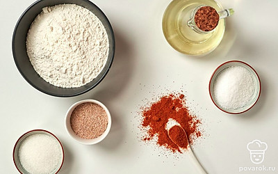 Муку заранее просейте, чтобы избежать попадания в тесто лишних комочков. Воду нагрейте до температуры немного выше комнатной. Приготовьте миску, пищевую пленку, бумагу для выпечки и полотенце. За 10-15 минут до выпекания разогрейте духовку до 190 градусов.