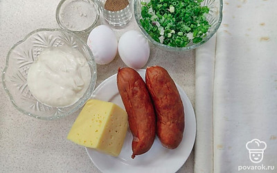 Измельчите молодой зеленый лук в тару, очистите 2 яйца, отрежьте от сыра часть и положите в тарелку, к сыру положите колбасу, поместите 3 ст.л. сметаны в отдельную тарелку, соль и перец высыпьте в тару