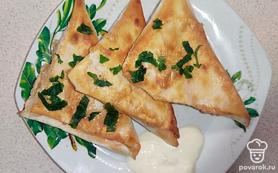 Выложите лаваши в тарелку, а затем разрежьте их, после посыпьте зеленью и добавьте сметану.