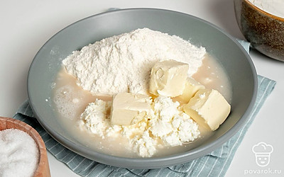 Замесите тесто. В миску с мукой выложите творог. Добавьте теплое сливочное масло, соль и перетрите руками ингредиенты до мелкой крошки. Затем влейте дрожжевую опару и замесите тесто, чтобы оно стало мягким и не липло к рукам. Дайте тесту отстояться в теплом месте 1-1,5 часа, накрытым пищевой пленкой или полотенцем.