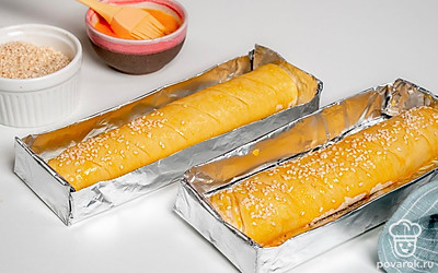 Поставьте багеты в духовку. Сделайте косые надрезы на багете. Смешайте яйцо с 1 ст. л. воды, солью и сахаром. Смажьте этой смесью багеты и посыпьте кунжутом. Поставьте багеты выпекаться на 40 минут в духовку при температуре 190 градусов.