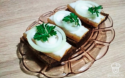 Подавайте в виде бутербродов с черным хлебом. Нарежьте лук кольцами, выложить сверху сала и украсьте петрушкой.