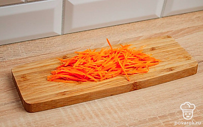 На разделочной доске нарежьте соломкой морковь или натрите ее на крупной терке. Измельчите чеснок.