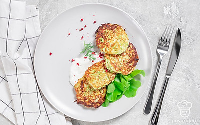 Подайте котлеты из кабачков и картофеля с ложкой сметаны.