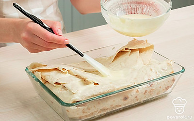 Испеките ачму. Форму для запекания смажьте растительным маслом. Выложите на дно лаваш, немного собрав его гармошкой. Смажьте первый слой яично-йогуртовой смесью. Выложите часть начинки, равномерно распределяя по поверхности. Повторяйте слои, пока не закончатся ингредиенты. Последний слой лаваша полейте остатками яично-йогуртовой смеси. Выпекайте пирог 30 минут в духовке, прогретой до 180 градусов.