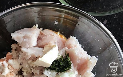 К желткам добавляем фарш трески, сливочное масло, зелень, специи, булку, измельчённый лук и чеснок.