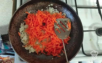 Следом выкладываем тёртую морковку. Обжариваем до готовности.