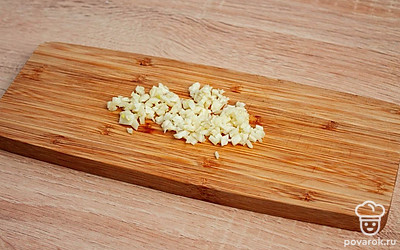 Капусту разрежьте вдоль, пополам. И уложите в контейнер. Хорошо просолите каждый листок. И оставьте для просола на 2 часа. Чеснок мелко порежьте .