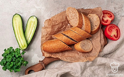 Для подачи багета со сливочным маслом возьмите деревянную пиалу, положите в нее чистое полотенце. Затем на полотенце выложите багеты, рядом поставьте десертную тарелку с дольками помидоров и огурцов.