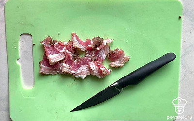 Нарежьте сало тонкими ломтиками, толщиной полсантиметра. Для того чтобы ломтики получились аккуратными и одинаковой толщины, можете предварительно поместить сало в морозилку на 5 минут. Его поверхность затвердеет, и нарезка получится идеальной. Нарежьте помидоры дольками, лук разделите на перья или мелко порежьте. Выложите сало, помидоры и лук на хлеб.