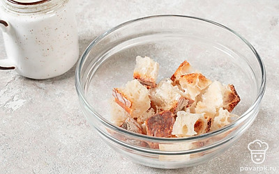 Нарежьте хлеб на маленькие кусочки. Залейте молоком, подогретым до 30-40°C. Оставьте размокать на 10 минут.