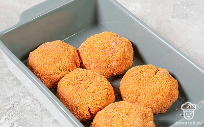 Смажьте форму для запекания сливочным маслом. Руками сформируйте из фарша котлеты, обваляйте их со всех сторон в панировочных сухарях и выложите в форму для запекания или на противень. Разогрейте духовку до 180°C.