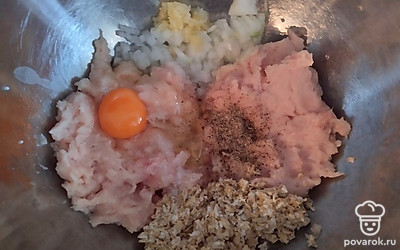 Хлопья замочить в воде. В это время нарезать лук, выдавить чеснок, измельчить куриное филе. Добавить яйцо, соль, перец. Хлопья отжать, все перемешать.
