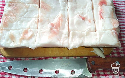 В каждом кусочке сала сделайте поперечные надрезы, но не до конца. Натрите полностью сало солью, затем перцем. В разрезы нашпигуйте кружочки чеснока. Переложите сало в емкость с крышкой и уберите в холодильник на 3 дня.