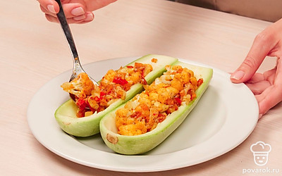 Нафаршируйте и запеките кабачки. Заранее включите духовку разогреваться до 180 градусов. Лодочки из кабачков заполните овощной начинкой и выложите в форму для запекания, смазанную растительным маслом. Форму с кабачками поставьте в разогретую духовку и запекайте кабачки 40 минут. На мелкой терке натрите твердый сыр. За 10 минут до готовности помажьте кабачки сверху сметаной и посыпьте тертым сыром.