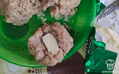Взять кружочек фарша, в середину положить кусочек масла, слепить котлету.