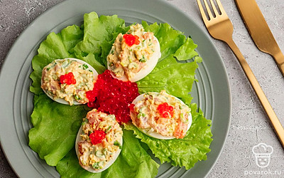 Полученную смесь выложите в готовые половинки яичного белка. Яйца фаршированные с семгой выложите на тарелку с салатными листьями и украсьте икрой на свой вкус. Приятного аппетита!