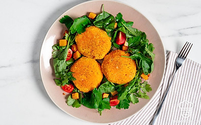 На сервировочную тарелку выложите салатные листья. На них положите готовые котлеты из тыквы.