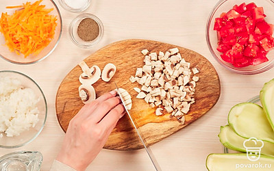 Подготовьте продукты. Кабачки разрежьте вдоль и с помощью ложки удалите мякоть и семена, мелко нарежьте репчатый лук, шампиньоны и помидор. Морковь натрите на крупной терке.