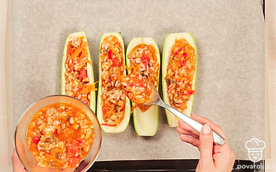 Запеките кабачки. Заполните лодочки из кабачков начинкой и выложите их на противень. Выпекайте фаршированные кабачки 40-45 минут в духовке при 180 градусах.