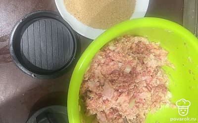 Шинкуем лук, добавляем к фаршу. Всыпаем приправы и добавляем 2 сырых яйца. Все перемешиваем. Формируем котлетки при помощи пресса и обваливаем в панировочных сухарях.