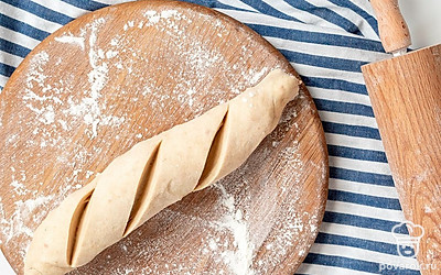 Сформируйте багеты. Стол присыпьте мукой. Тесто разделите на четыре части. Из каждой раскатайте пласт, сверните в рулеты.