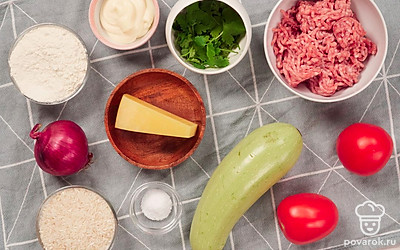 Очистите и вымойте репчатый лук. Накрошите его мелкими кубиками. Кабачки вымойте, очистите от кожицы, нарежьте толстыми колечками и из каждого вырежьте сердцевину и семечки. Промойте рис и замочите его в холодной воде на 10-15 минут. Петрушку для подачи промойте, высушите и разделите на небольшие веточки.