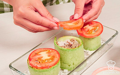 Приготовьте начинку и нафаршируйте кабачки. Готовый фарш смешайте с вареным рисом.Форму присыпьте мукой, выложите кабачковые кольца и каждое кольцо заполните фаршем. Сверху выложите по одному помидорному кружочку и смажьте майонезом. Отправьте в духовку противень с фаршированными кольцами кабачков на 45 минут. Натрите сыр на мелкой терке и за 5 минут до готовности посыпьте им каждое кабачковое кольцо.