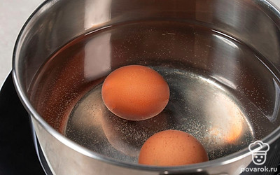 Положите куриные яйца в небольшую кастрюлю, залейте водой и поставьте на сильный огонь. Варите 10 минут после закипания. Остудите яйца в ледяной воде и очистите их от скорлупы.