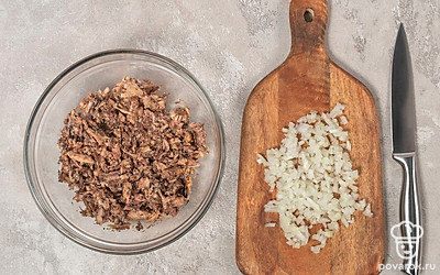 Мелко покрошите репчатый лук. Добавьте его в миску с сайрой и хорошенько перемешайте.