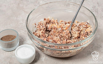 Приправьте фарш солью и черным молотым перцем. Хорошенько перемешайте. Если фарш получается сухим, влейте жидкость, слитую из консервов.