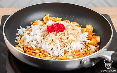 Выложите в сковороду к кимчи отварной рис, перцовую пасту «Кочудян» и соевый соус.