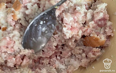 Добавьте булку в фарш. Все перемешайте и посолите.
