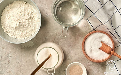 Муку несколько раз просейте. Нагрейте воду до 38-40 градусов. Подготовьте пергамент для выпекания. 