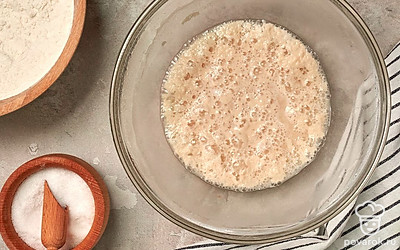 Смешайте продукты для опары: соедините воду с дрожжами, 2 ст. л. муки, солью и сахаром. Все перемешайте и оставьте на 15-20 минут.