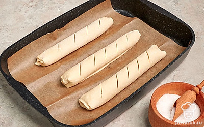 Уберите полотенца и растяните пергамент. На багетах сделайте несколько надрезов наискосок. Выпекайте в разогретой до 200 градусов духовке в течение 25 минут.