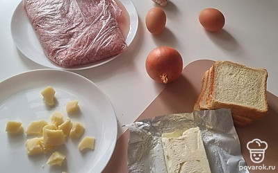 Подготовьте все необходимые продукты: фарш мясной из свинины, 6 ломтиков хлеба, 4 яйца, пармезан, лук, чеснок, масло и специи. При желании можете добавить любимую зелень.