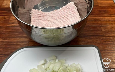 В миску выложите куриный фарш. Репчатый лук нарежьте мелкими кубиками и добавьте к фаршу.