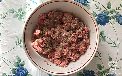 Добавьте к фаршу специи, соль и, по желанию, сахар. Тщательно перемешайте руками. 