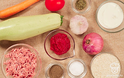 Чтобы рационально использовать время при приготовлении фаршированных кабачков в кастрюле, заранее вымойте все овощи. Помидоры, морковь, репчатый лук и чеснок очистите от кожуры и шелухи. Морковь натрите на крупной терке, а репчатый лук нарежьте кубиками. Чеснок мелко порубите ножом или выдавите через специальный пресс.