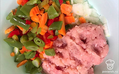 Нарежьте лук мелким кубиком и смешайте его с куриным фаршем и разморозившимися овощами. Сыр натрите на крупную терку и половину добавьте в получившийся фарш.