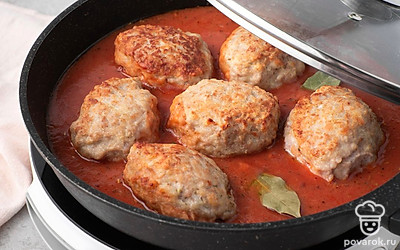 Добавьте в соус лавровый лист и все как следует перемешайте. Когда соус закипит, выложите в него обжаренные котлеты. Уменьшите огонь до слабого и прикройте сковороду крышкой. 