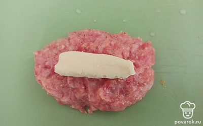 Из фарша сделайте заготовки под котлету. Выложите в середину каждой заготовки по ломтику сливочного масла, заверните.