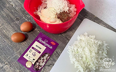 В отдельной чаше смешайте нарезанное куриное филе, майонез, соль, перец и муку. Добавьте к ним яйца, сушеный чеснок и нарезанный лук.