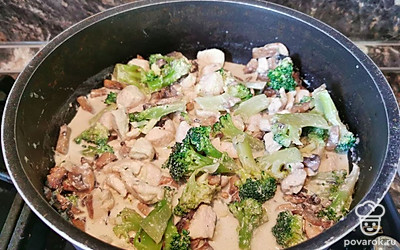 Тушеную курицу в сливках переложите к грибам с брокколи, присоедините к блюду мелкорубленный чеснок, перемешайте ингредиенты и приправьте солью и перцем по вкусу.